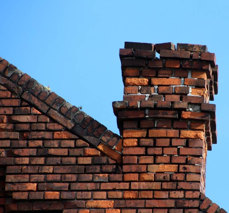 Damaged chimney on an Midway City home showing cracks and missing mortar